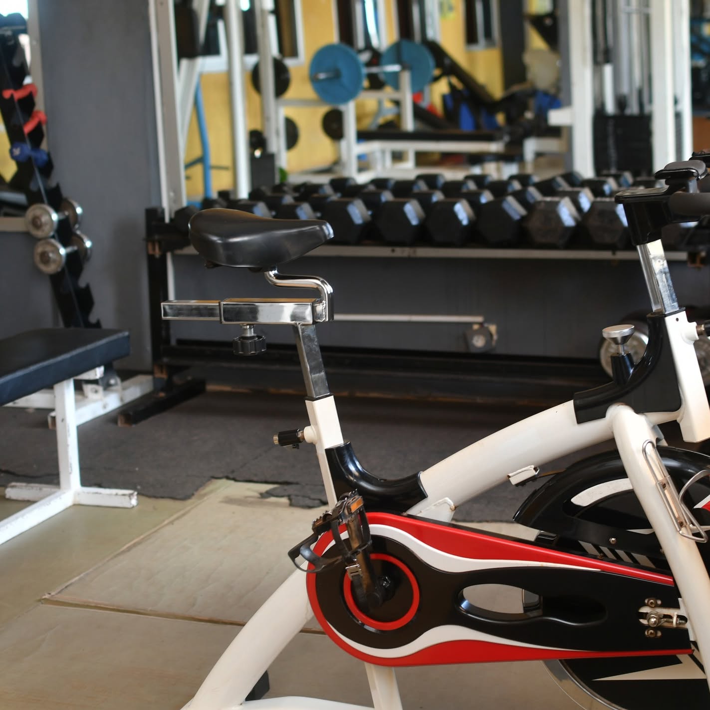 Vélo de spinning et rack d'haltères en arrière-plan, salle CFC