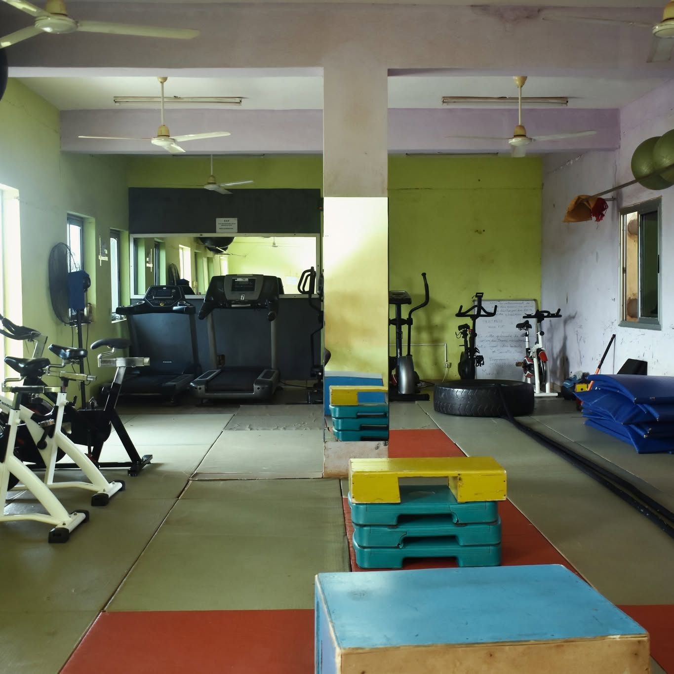 Espace fonctionnel du Centre Fitness chez Cissé, steppers et tapis de sol