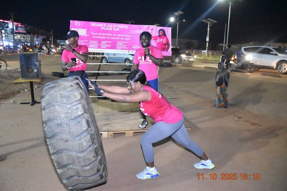 Séance de fitness plein air du CFC en soirée : le groupe en maillots roses avec la banderole de l'événement